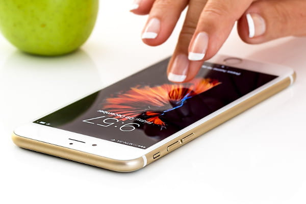 5 aplicativos de serviços para divulgar seu negócio: mulher tocando a tela do celular.