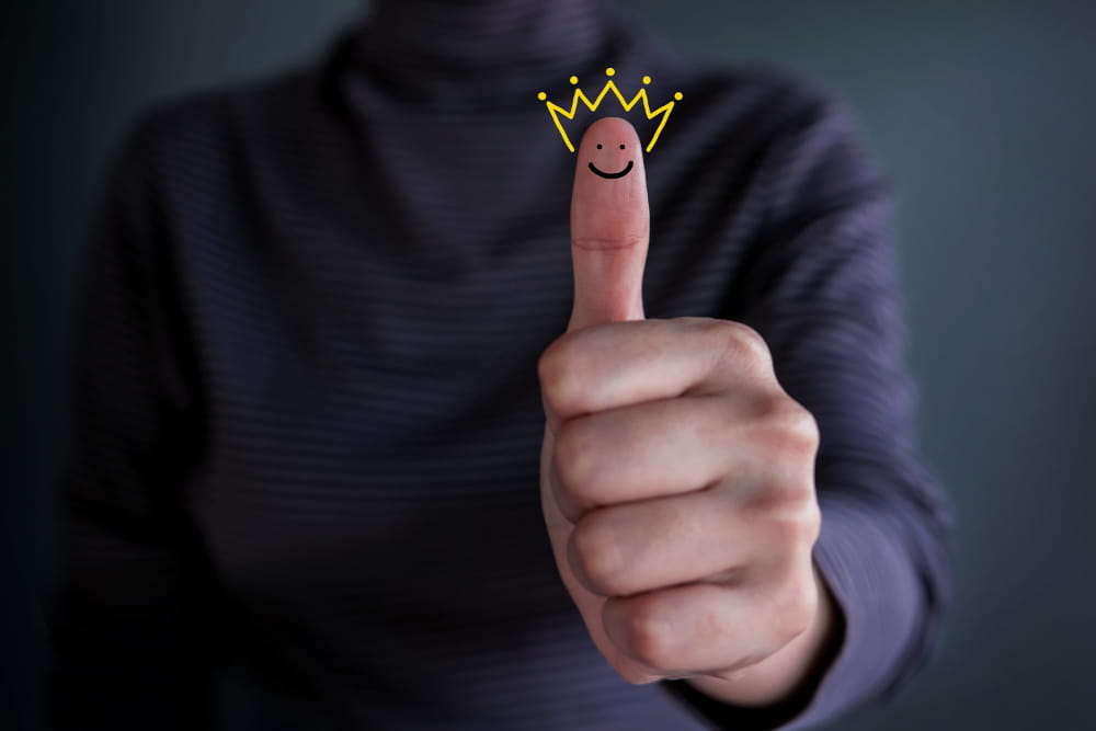Como aumentar a percepção de valor para o cliente: dedo de um homem com um desenho de coroa em volta.