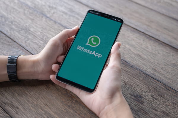 Como utilizar o Whatsapp como ferramenta de marketing: mãos de homem segurando celular com whatsapp na tela.