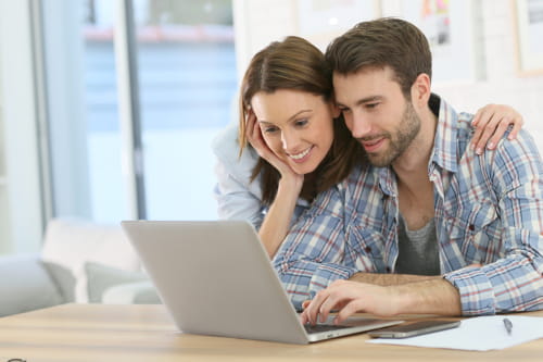 Homem e mulher analisando dicas de marketing digital para pequenas empresas no notebook