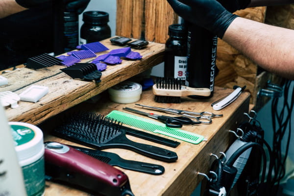 Dicas para impulsionar sua barbearia: profissional preparando aparelhos para barbear.