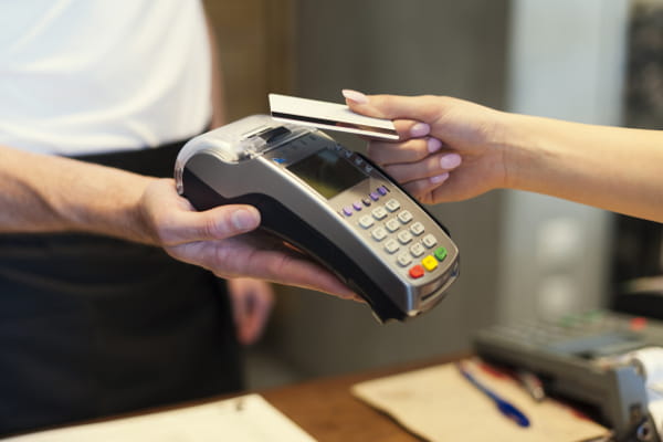 Dicas para vender mais em datas comemorativas: cliente pagando uma compra com seu cartão de crédito.