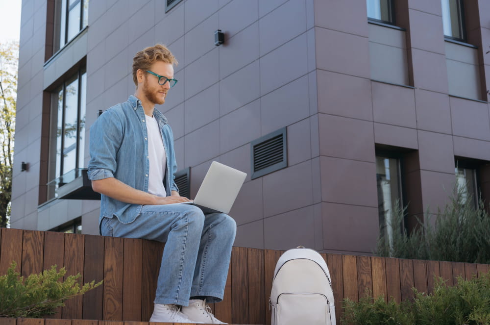 Linkedin para B2B: veja como utilizar: homem sentado em uma praça acessando o notebook.