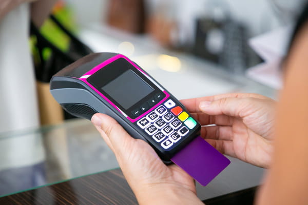 Razões para diversificar os meios de pagamento em seu negócio: pessoa digitando a senha do seu cartão de crédito.