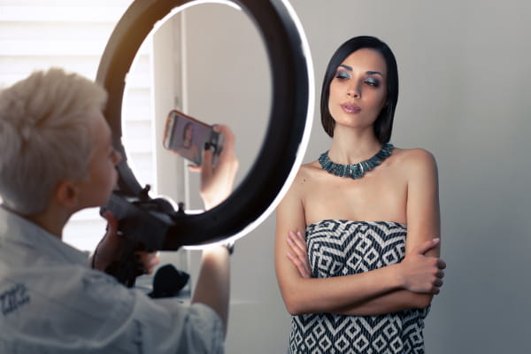 SEO para loja de roupas online: fotógrafo tirando fotos de um colar no pescoço de uma de uma modelo.